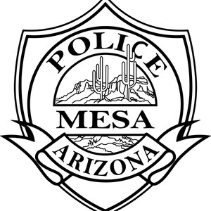 May include: Black and white Mesa Arizona Police badge. The badge is shield-shaped with the word "POLICE" arched across the top. Below, the word "MESA" is centered, and "ARIZONA" is on a banner. A desert landscape is in the center.