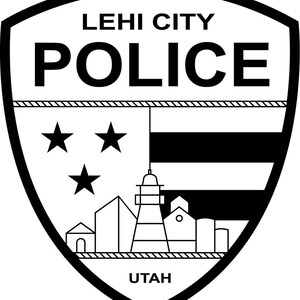May include: Black and white Lehi City Police badge. The badge features the words "LEHI CITY POLICE" at the top, with "POLICE" in large letters. Below are three stars, a flag design, and a city skyline. The word "UTAH" is at the bottom.