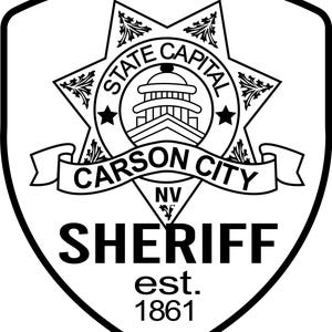 Könnte beinhalten: Schwarz-weißes Carson City Sheriff-Abzeichen. Das Abzeichen zeigt ein Sterndesign mit den Worten "State Capital" und einer Gebäudeillustration. Der Text "Carson City" befindet sich auf einem Banner, und "Sheriff" und "est. 1861" stehen darunter.