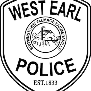 May include: Black and white West Earl Police badge. The badge is shield-shaped with the words "WEST EARL" at the top. A circular emblem in the center features a farm scene. The word "POLICE" is at the bottom, with "EST. 1833" below.