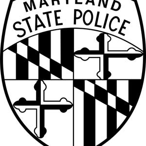 May include: A black and white Maryland State Police badge. The shield-shaped emblem features the words "MARYLAND STATE POLICE" at the top. The design includes a checkered pattern, vertical stripes, and two black crosses with white accents.