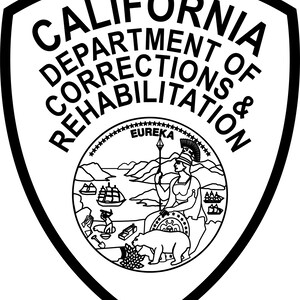 May include: A black and white shield-shaped emblem featuring the text CALIFORNIA DEPARTMENT OF CORRECTIONS & REHABILITATION. The center contains the California state seal with a figure, a bear, a ship, mountains, and the word EUREKA.