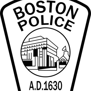 May include: Black and white Boston Police badge. The badge features the words "BOSTON POLICE" at the top, a circular emblem with a building and the text "A.D. 1630" at the bottom. The badge has a shield shape.