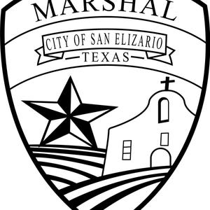 May include: Black and white shield-shaped emblem with the word "MARSHAL" at the top. Below, a banner reads "CITY OF SAN ELIZARIO TEXAS." A star and a church are depicted within the shield, along with horizontal lines.