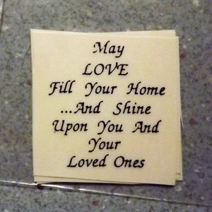 May include: A beige card with black calligraphy that reads "May LOVE Fill Your Home...And Shine Upon You And Your Loved Ones".
