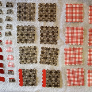 May include: Assortment of red and black patterned paper squares with scalloped edges. Some squares have a geometric pattern, while others have a plaid pattern.