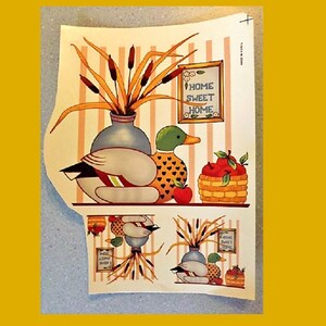 May include: A vintage-style print featuring a pair of ducks, a vase of reeds, and a basket of apples. The print has a striped background and a sign that reads "Home Sweet Home".