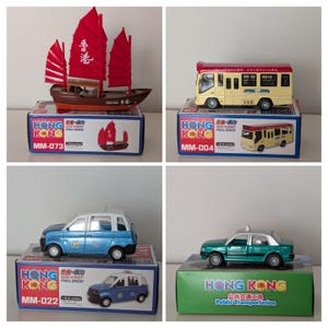 Könnte beinhalten: Vier Druckguss-Modellfahrzeuge. Ein Dschunkenboot mit roten Segeln, ein gelber Bus, ein blaues Taxi und ein grünes Taxi. Jedes Modell befindet sich auf einer Box mit "HONG KONG" und "DIE CAST PULL BACK". Die Boxen haben Modellnummern.