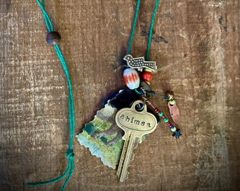 found-bit talisman: "ahimsa", stamped key with cloth swatches, silver bird, bell and glass beads