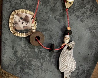 bottle cap talisman necklace: "yes" stamped bottle cap and Feather Lite key on red nylon cord
