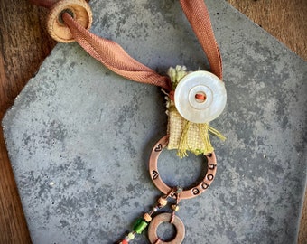 found-bit talisman: "hope" with button, bell, acorn and ribbon