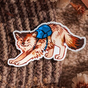 May include: A sticker featuring a cartoon fox with a blue backpack, stretching. The fox has brown, tan, and white fur. The sticker is on a white background, with a brown woven texture in the background.