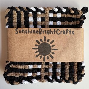 May include: Woven pot holder in black, white, and tan. The pot holder is wrapped with a brown paper band featuring the text "SunshineBrightCrafts" and a sun graphic. The woven design creates a textured appearance.