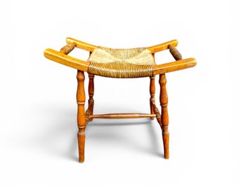 Taburete/silla de madera rústica vintage tallada a mano con detalle retorcido y asiento de junco, estilo arte popular.