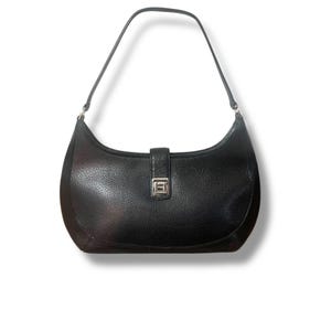 Pode incluir: Bolsa de ombro de couro preto com design curvo. A bolsa apresenta uma única alça de ombro e um fecho de fivela prateada. O couro tem uma aparência texturizada e a bolsa está sobre um fundo branco.