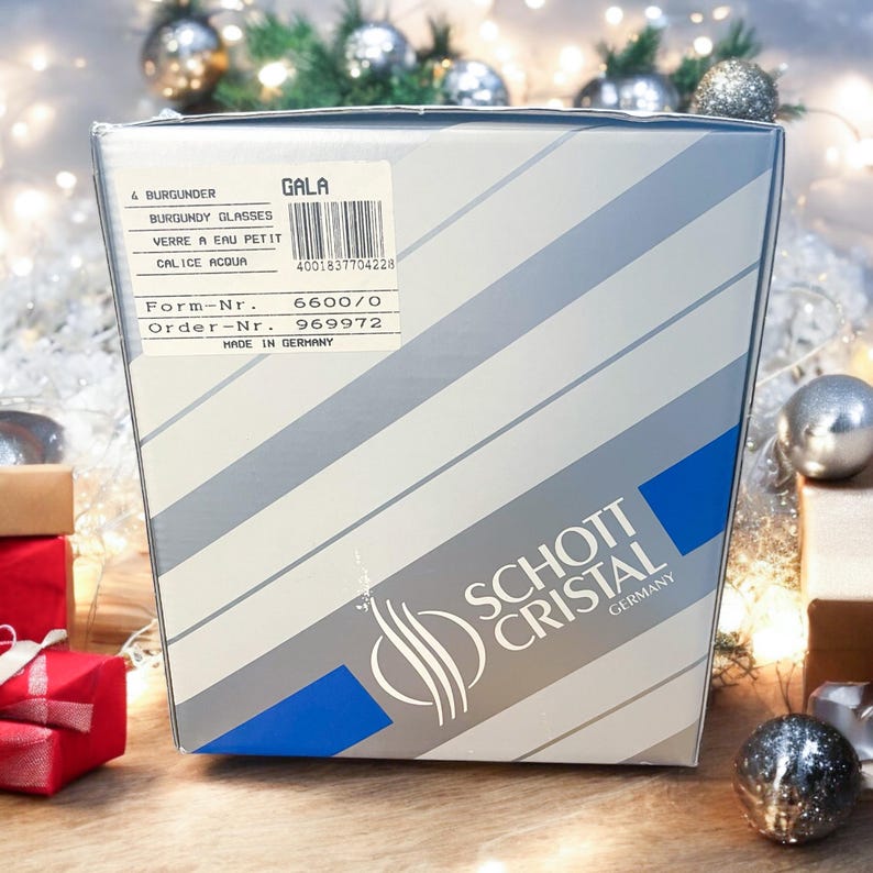 Może przedstawiać: Białe pudełko z niebiesko-srebrnym logo Schott Cristal. Pudełko jest oznaczone tekstem "GALA" i "4 BURGUNDER BURGUNDY GLASSES VERRE A EAU PETIT CALICE ACQUA 4001837704228 Form-Nr. 6600/0 Order-Nr. 969972 MADE IN GERMANY".