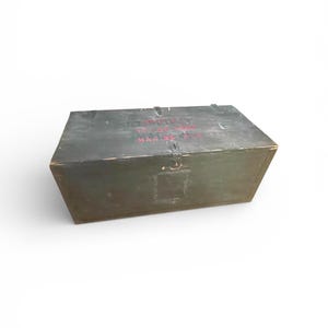 May include: A dark green wooden box with red text on the top. The box is rectangular with a hinged lid and a metal clasp. The background is plain white.