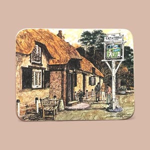 Puede incluir: Un posavasos rectangular con una pintura a la acuarela de un pub con techo de paja, "The Cat & Fiddle". El letrero muestra un paisaje. El posavasos tiene un fondo marrón claro y una forma ligeramente redondeada.
