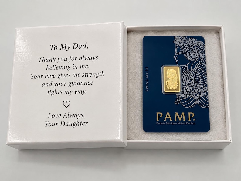 Puede incluir: Una caja de regalo blanca que contiene una peque&ntilde;a barra de oro en una tarjeta azul PAMP. La tapa interior presenta el texto: To My Dad, Thank you for always believing in me. Your love gives me strength and your guidance lights my way. Love Always, Your Daughter.