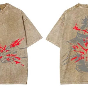 May include: A tan, short-sleeved t-shirt with a graphic design on the front and back. The front features a hand with red splatter, and the back displays a figure with red accents. The shirt has a vintage, washed appearance.