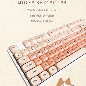 May include: A 130-key full set of double-shot matte PC keycaps with soft RGB diffusion, labelled Utopia Keycap Lab. The keyboard features a gradient of light beige to peach-coloured keys with black lettering, and a cartoon cat illustration.