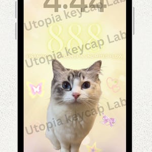 May include: A smartphone screen displaying a digital wallpaper with a white and grey cat, the time 4:44, the text Swipe up to unlock, Utopia keycap Lab, Financial dance & unlimited flow, and a magnet for miracles, st and endless abundance.