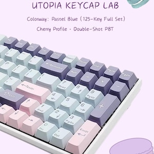 Könnte beinhalten: Eine mechanische Tastatur mit einem 125-Tasten-Set in Pastellblau, Rosa und Lila im Cherry-Profil. Der Text UTOPIA KEYCAP LAB, Colorway: Pastel Blue (125-Key Full Set), und Cherry Profile · Double-Shot PBT ist zu sehen.