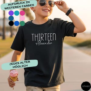 Könnte beinhalten: Ein schwarzes T-Shirt mit kurzen Ärmeln, das den weißen Schriftzug THIRTEEN und den Namen Alexander in Schreibschrift zeigt. Das T-Shirt wird mit einer Farbpalette dargestellt, die verschiedene Optionen für den Aufdruck zeigt.