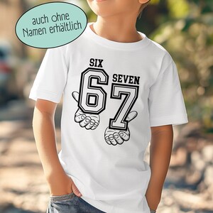 May include: A white short-sleeved t-shirt featuring a black graphic print of the number 67 with the words SIX and SEVEN above the digits. The design includes illustrations of hands positioned beneath each number. A speech bubble reads auch ohne Namen erh&auml;ltlich.