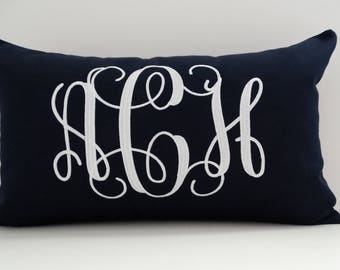 May include: A navy blue throw pillow with white embroidered monogram letters "A C H".