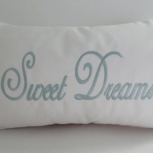 May include: White pillow with the words "Sweet Dreams" embroidered in light blue.