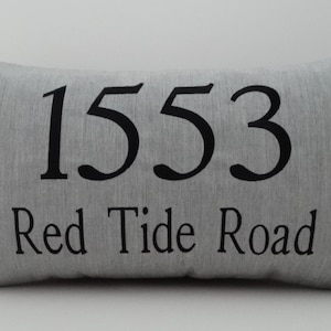 May include: Gray pillow with black text that reads "1553 Red Tide Road".
