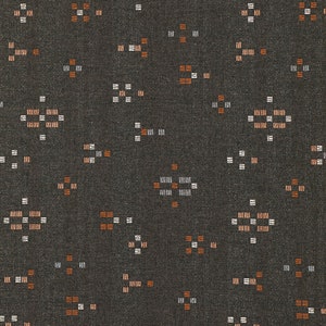 May include: A dark gray fabric with a repeating pattern of small white and orange squares. The pattern is a geometric design that resembles a star.