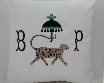 May include: White pillow with a black and green umbrella, a leopard walking under it, and the letters "B" and "P" embroidered on either side.