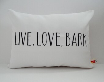 May include: White pillow with black text that reads "LIVE, LOVE, BARK".