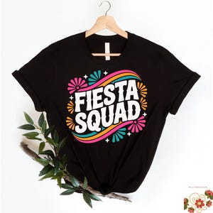 May include: A white ceramic mug with a black handle and the text "But First, Coffee" in a black, handwritten-style font. The mug is on a white surface.