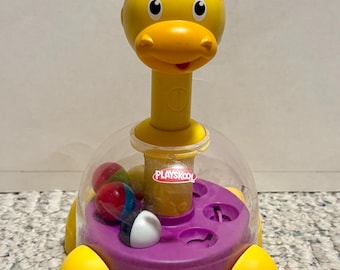 Juguete giratorio Playskool con forma de jirafa y trompo para bebés y niños pequeños.