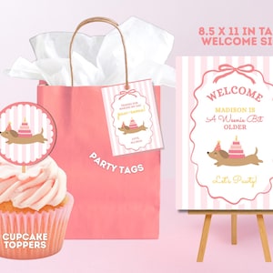 Puede incluir: Una bolsa de regalo rosa con papel de seda blanco, un cupcake con adorno redondo, una etiqueta rectangular y un letrero de bienvenida de 21,6 x 27,9 cm. Todos los artículos muestran un perro salchicha con gorro de fiesta y pastel.