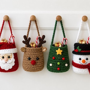 Può includere: Quattro sacchetti all'uncinetto appesi con disegni natalizi: un Babbo Natale rosso, una renna marrone con corna, un albero di Natale verde con decorazioni e un pupazzo di neve bianco con cappello nero e sciarpa rossa, ognuno con regalo e bastoncino.