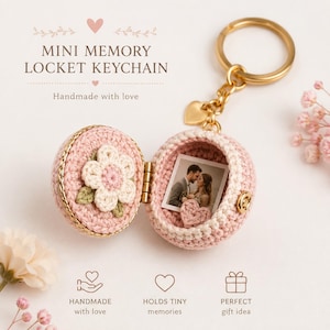 Pode incluir: Um porta-chaves com medalhão redondo em croché, feito com fio rosa suave e creme. O medalhão abre-se para revelar uma pequena fotografia quadrada de um casal e um minúsculo coração em croché. Inclui um anel metálico dourado e um pequeno pendente.