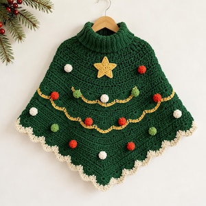 May include: A dark green crochet poncho featuring a ribbed turtleneck collar, a yellow star appliqué at the centre, and two wavy yellow yarn garlands. The garment is decorated with small red, white, and green pom-poms and a cream scalloped edge.