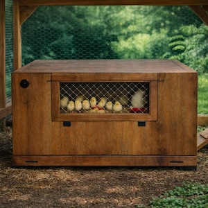 May include: A wooden chicken coop with a wire mesh window, housing several yellow chicks. The coop is stained a warm brown and sits on a bed of hay. The background features lush green foliage.