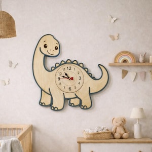 Pode incluir: Um relógio de parede de madeira em forma de dinossauro, com acabamento em madeira clara e contorno azul. O mostrador do relógio apresenta números pretos e ponteiros vermelhos. O relógio está montado numa parede clara num quarto de criança.
