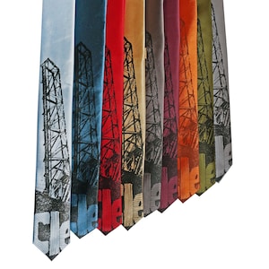May include: A set of nine silk ties featuring a black and white illustration of an oil rig. The ties are in various colors, including blue, red, orange, yellow, green, and brown.