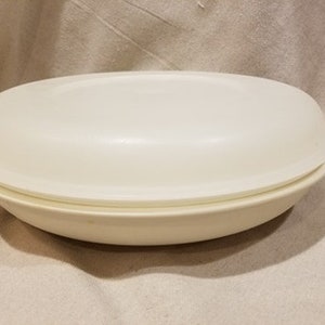 May include: A white oval-shaped serving dish with a matching lid. The dish is made of a smooth, glossy material.