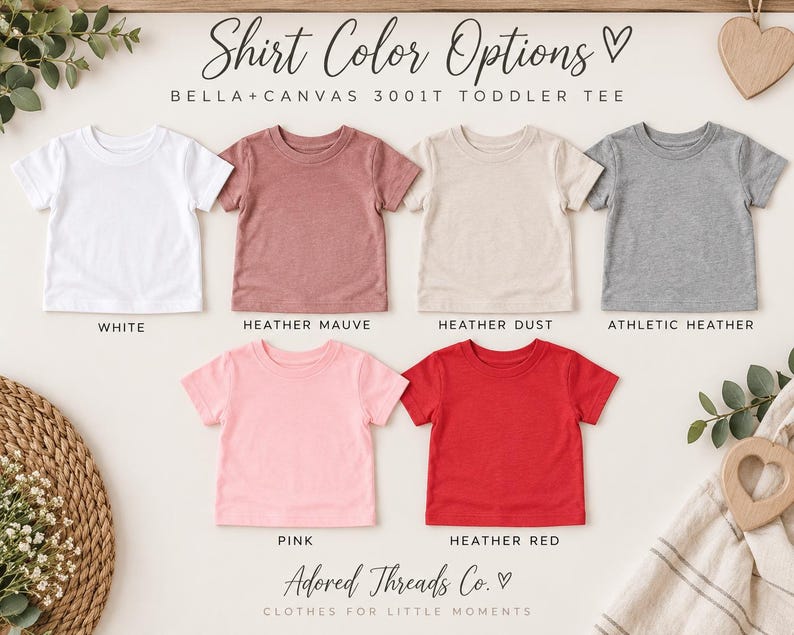 May include: A collection of six Bella+Canvas 3001T toddler t-shirts in white, heather mauve, heather dust, athletic heather, pink, and heather red. The text reads Shirt Color Options, Bella+Canvas 3001T Toddler Tee, and Adored Threads Co.