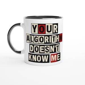 Peut inclure: Mug en céramique blanche avec une anse et un bord noirs. Le mug affiche le texte "YOUR ALGORITHM DOESN'T KNOW ME" en caractères gras et carrés, avec des accents rouges. Un design humoristique et moderne.
