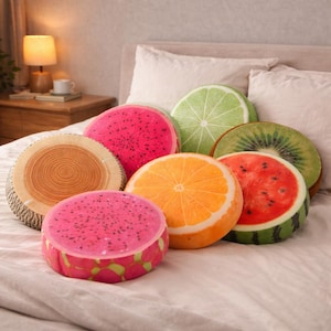 Può includere: Una collezione di cuscini rotondi a forma di frutta, tra cui anguria, arancia, kiwi, lime e frutto del drago. I cuscini sono disposti su un letto con biancheria da letto bianca. I cuscini sono dai colori vivaci e aggiungono un tocco giocoso all'arredamento della camera da letto.