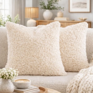 May include: A white ceramic mug with a black handle and the text "But first, coffee" in a black, handwritten-style font. The mug is on a white surface.