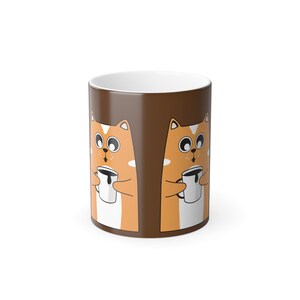 May include: A brown ceramic mug with a repeating cartoon cat design. The cats are orange with white markings and hold white mugs. The inside of the mug is white.